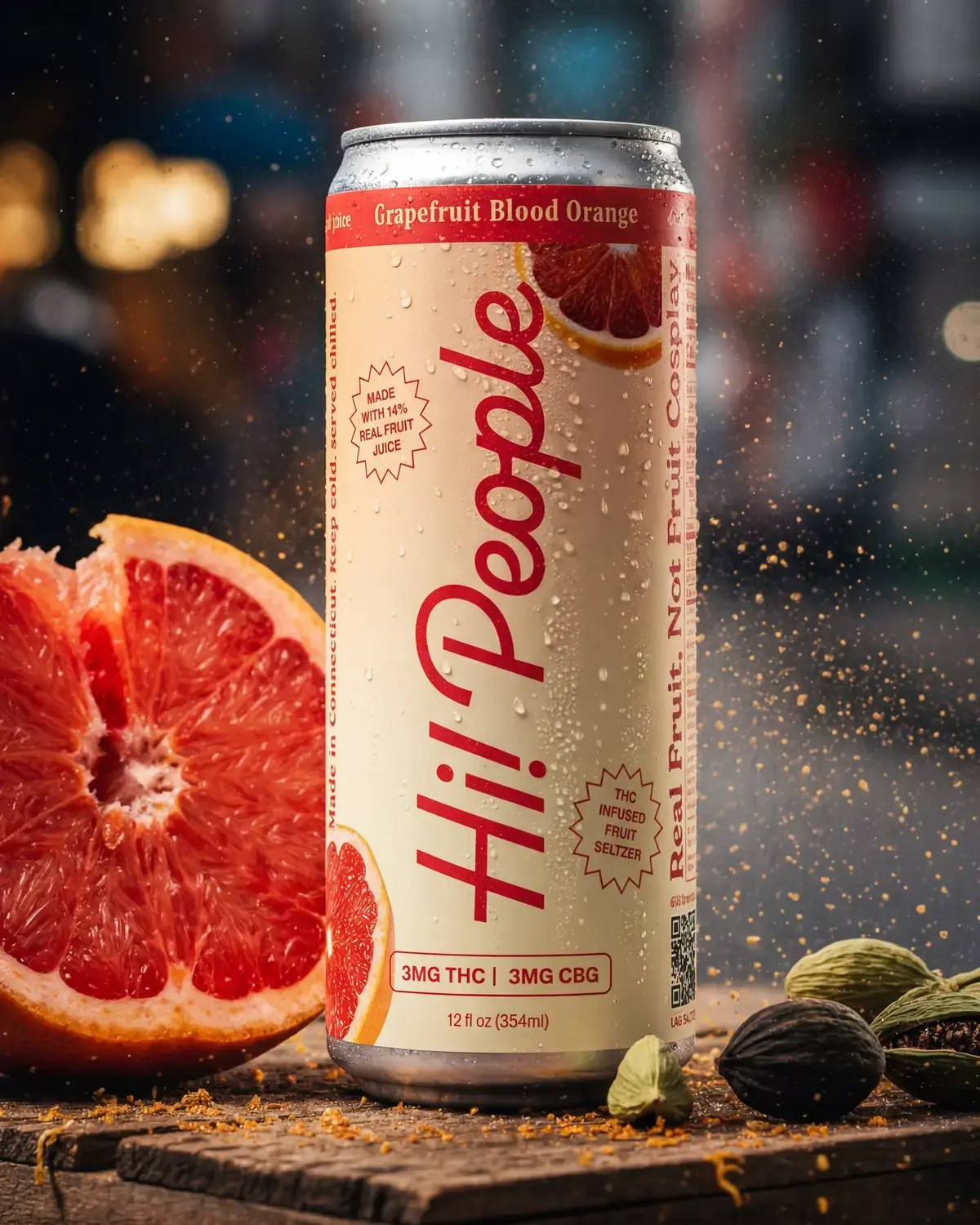 A can of Hi! People Grapefruit Blood Orange seltzer on a wooden crate beside a halved grapefruit
